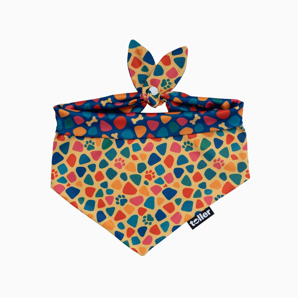 Colorful dog bandana with paw prints and bone patterns on a white background
