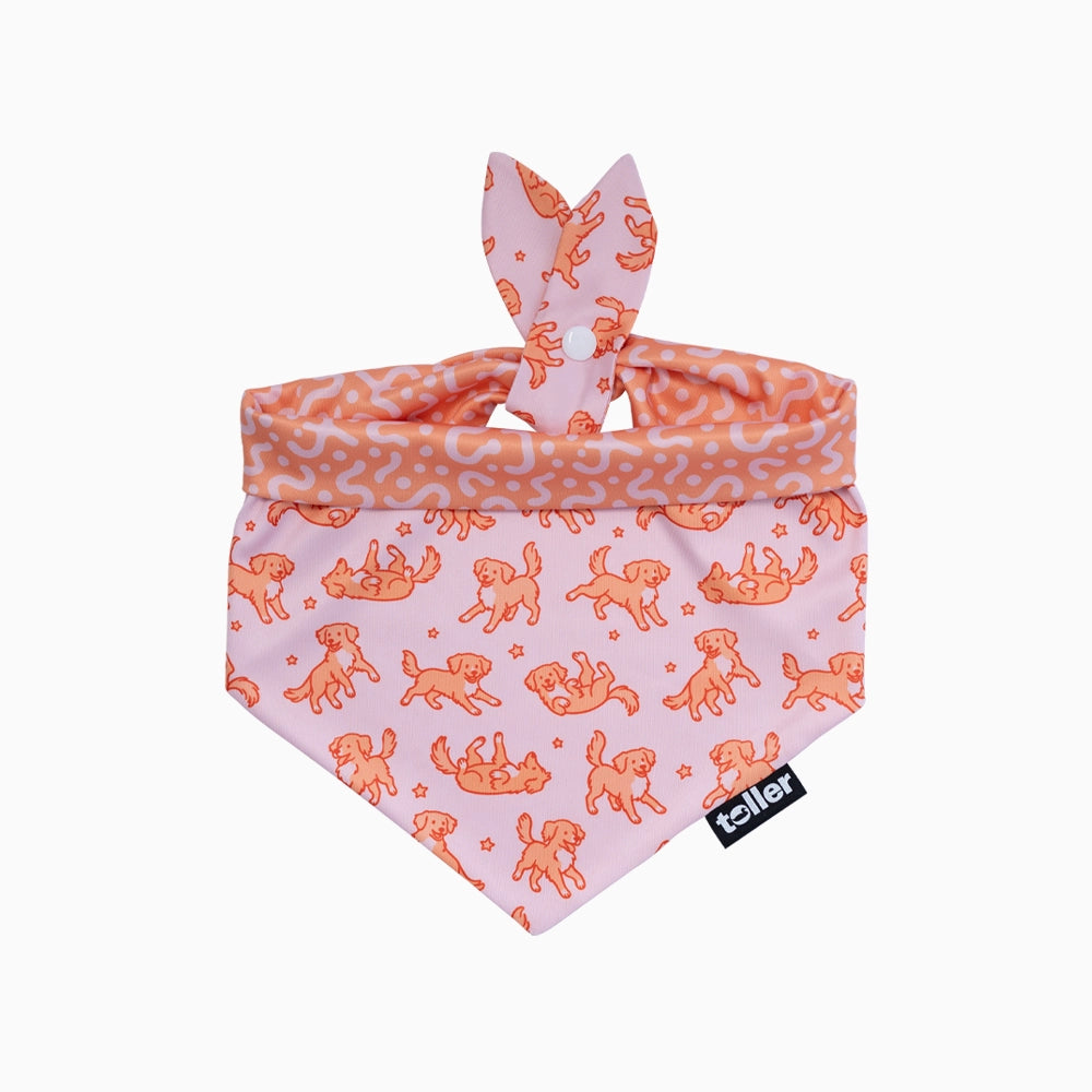 Dog bandana with dog pattern on pink background, featuring a brand label.