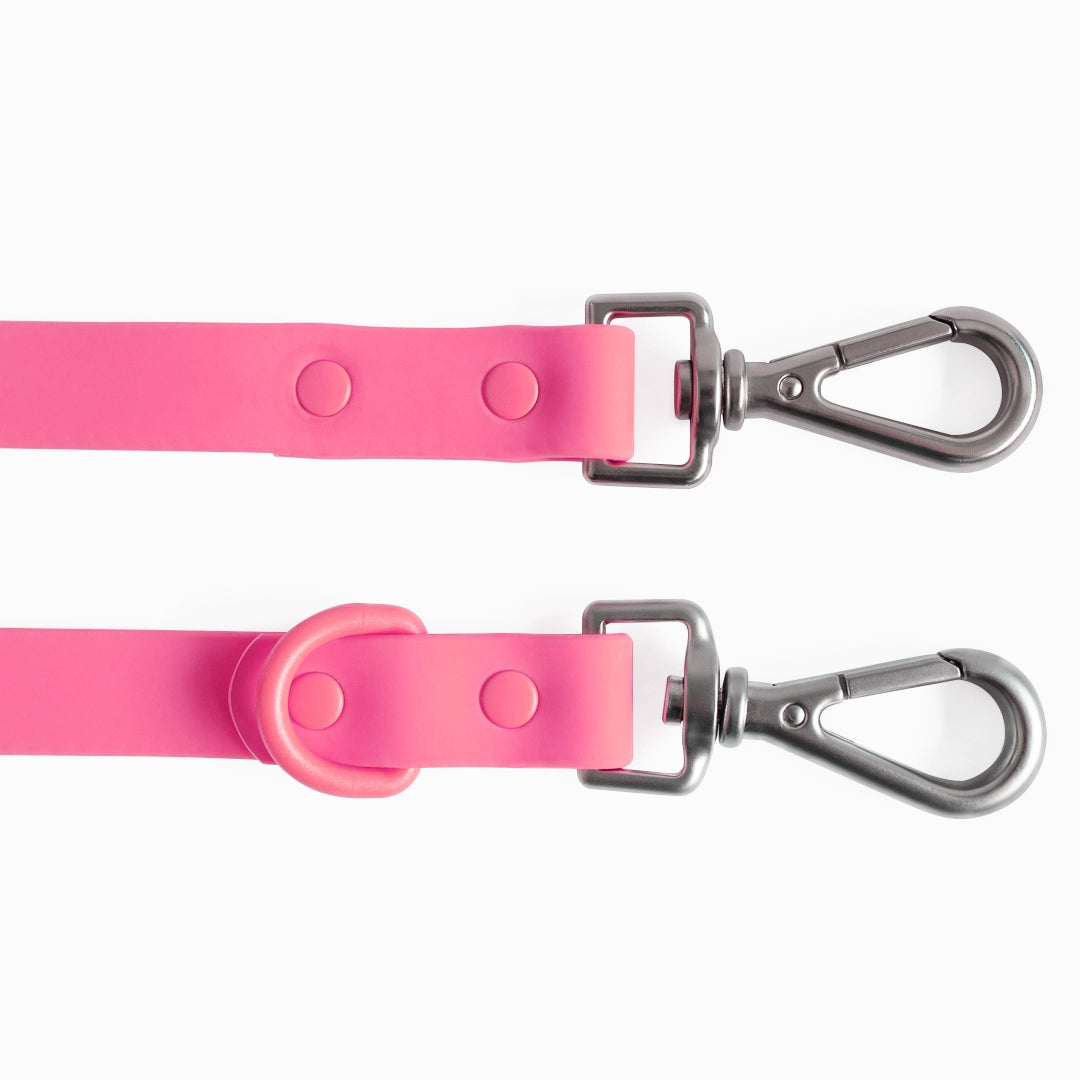 Two pink dog leashes with metal clasps on a white background
