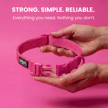 Pink dog collar held by hands against a pink background with text about strength, simplicity, and reliability.