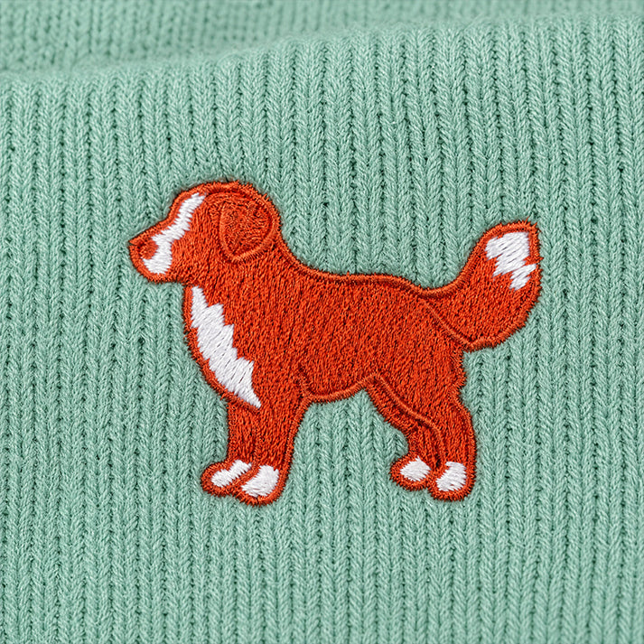 Embroidered dog design on a green knitted fabric