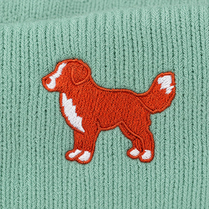 Embroidered dog design on a green knitted fabric