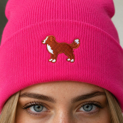 Person wearing a pink beanie with a dog illustration, close-up of face.