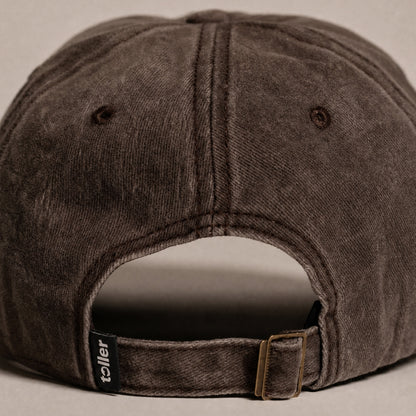 Brown baseball cap with 'teller' brand label on a beige background