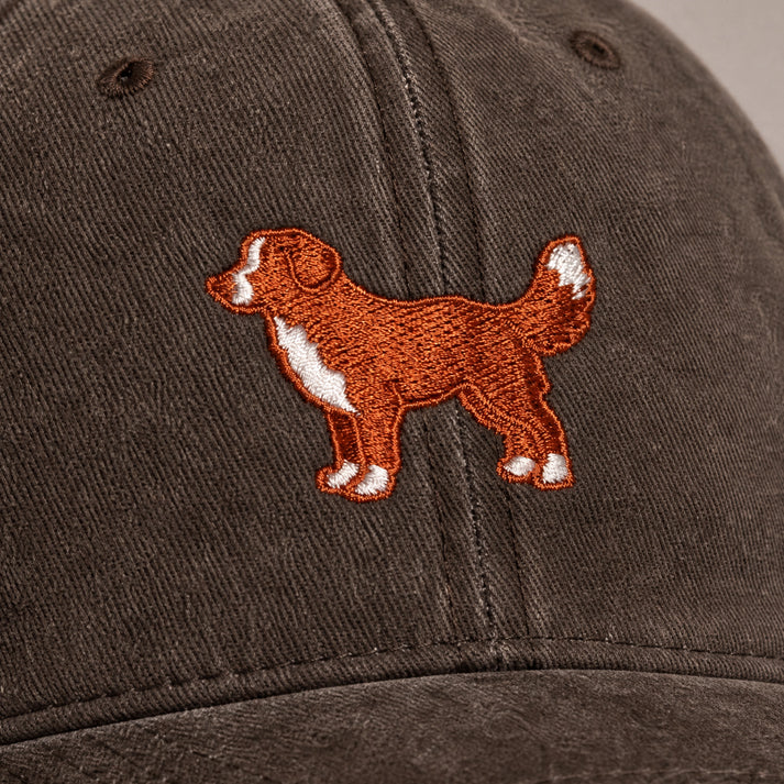 Brown cap with embroidered dog design on a plain background