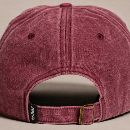 Maroon cap with a visible brand logo on a beige background