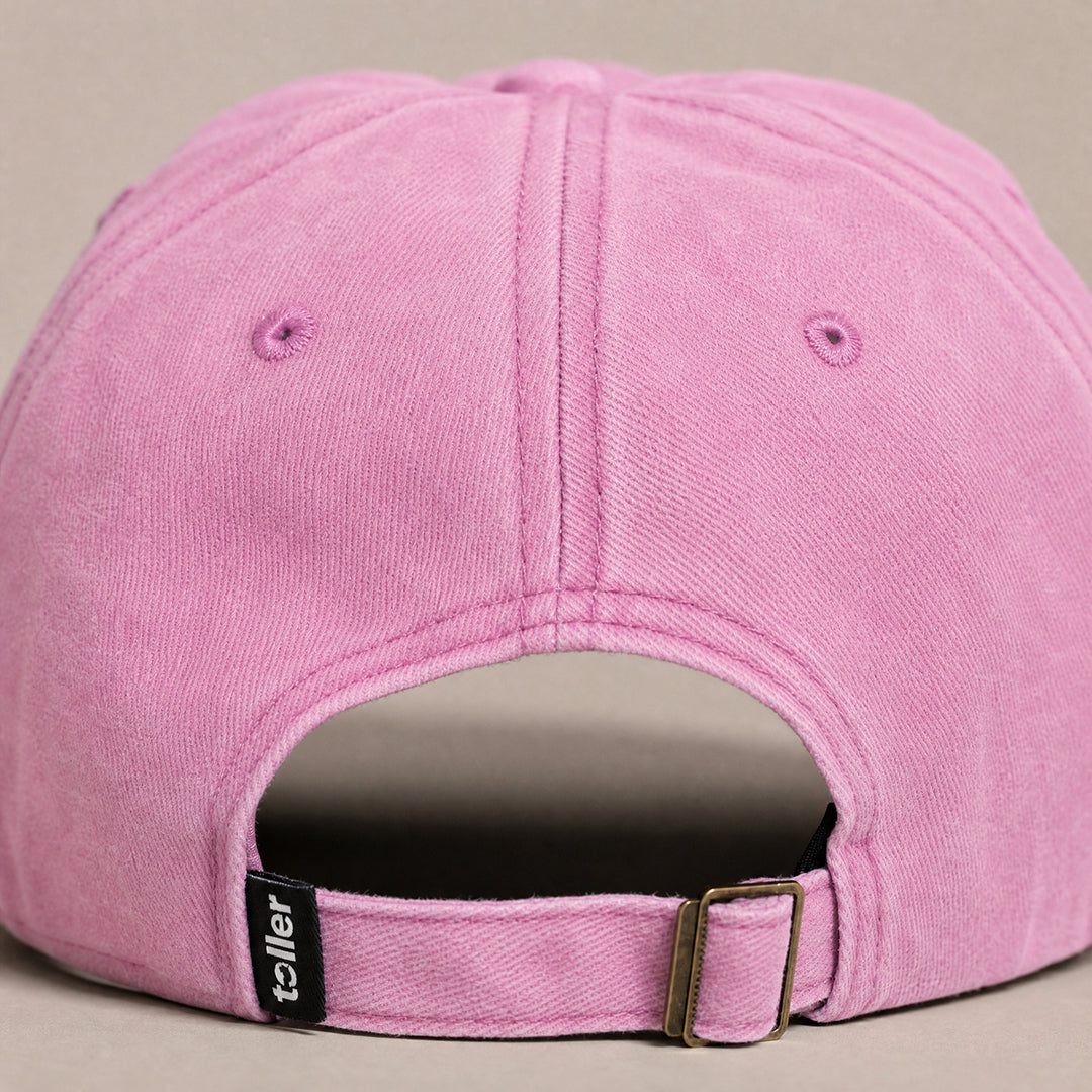Pink cap with a visible brand label on a beige background