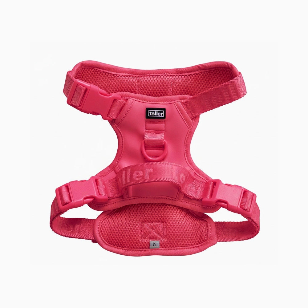 Pink dog harness with 'toller' branding on a white background