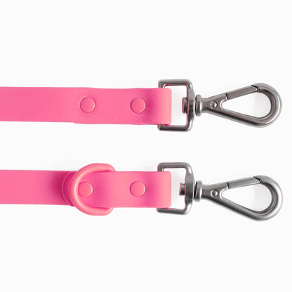 Two pink dog leashes with metal clasps on a white background