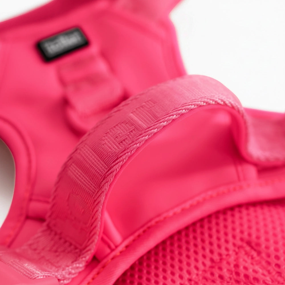 Close-up of a pink protective vest with a brand label on a white background