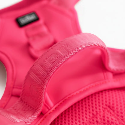 Close-up of a pink protective vest with a brand label on a white background